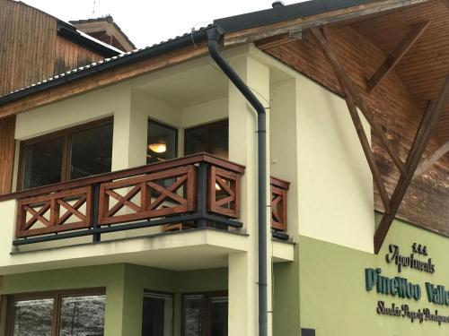 a building with a wooden balcony on the side of it at Apartmán Luky in Vyšné Ružbachy