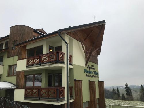a building with wooden balconies on the side of it at Apartmán Luky in Vyšné Ružbachy