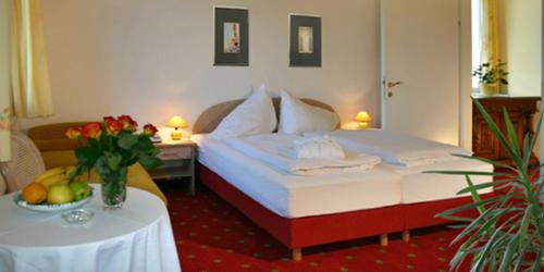 a hotel room with a bed and a table with flowers at Villa Auguste in Pörtschach am Wörthersee