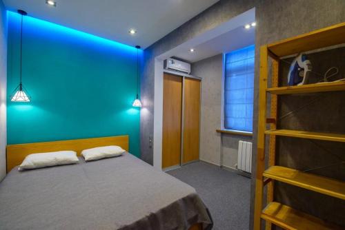 een slaapkamer met een bed met een blauwe muur bij n-Joy Venice in Novorossiejsk