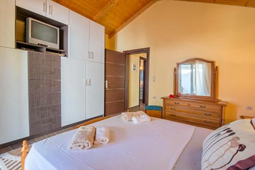 een slaapkamer met 2 handdoeken op een bed en een tv bij Filomila House in Gaios