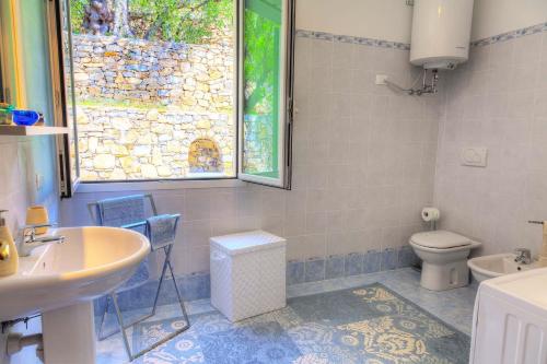 een badkamer met een wastafel, een toilet en een raam bij Ü Maxeu- Maestrale in Cervo