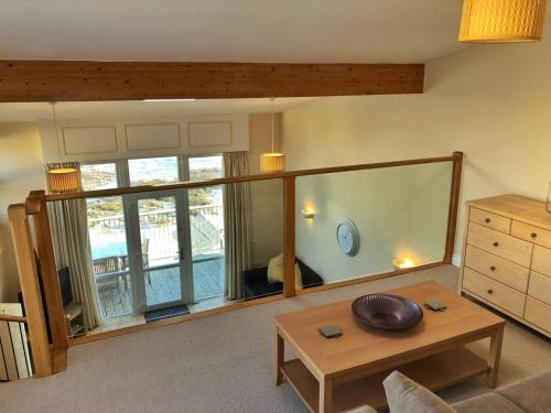 a living room with a table and a large window at Seafront House, Westward Ho! in Westward Ho