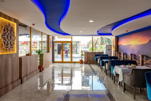 a restaurant with blue ceilings and tables and chairs at Linda Expo Palace in Antalya