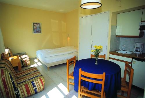 サント・マキシムにあるHôtel Lou Paouvadouのテーブル付きの部屋、ベッド付きのキッチンが備わる客室です。