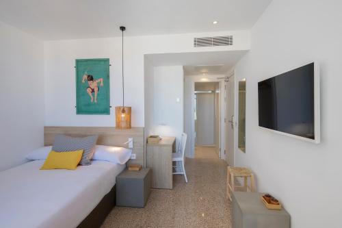 a bedroom with a bed and a flat screen tv at whala!fun in El Arenal