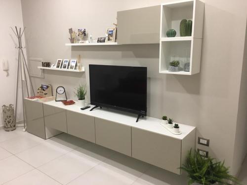 una sala de estar con TV en un armario blanco en Il profumo dei Sassi Holiday Home en Matera