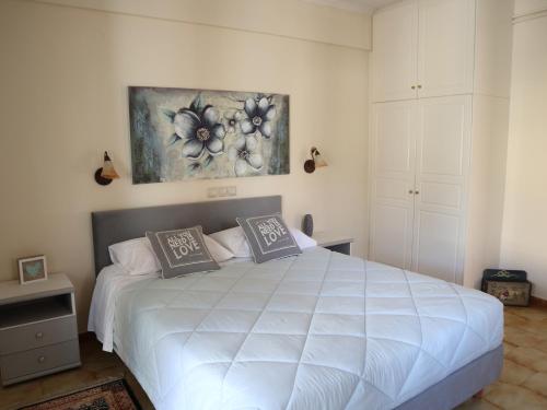 
a bedroom with a bed, a desk and a painting on the wall at Fulvia Apartments in Kassiopi
