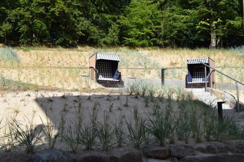 two chairs sitting in the sand on a beach at Sellinkoje in Residenz Waldidyll in Ostseebad Sellin