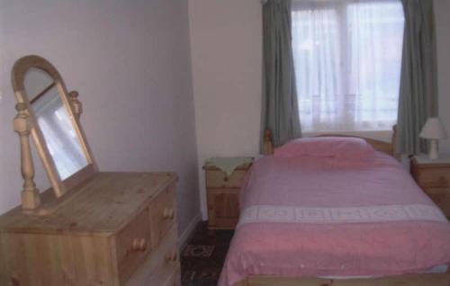 a bedroom with a bed and a dresser and a mirror at Spa Holiday Apartments in Bridlington