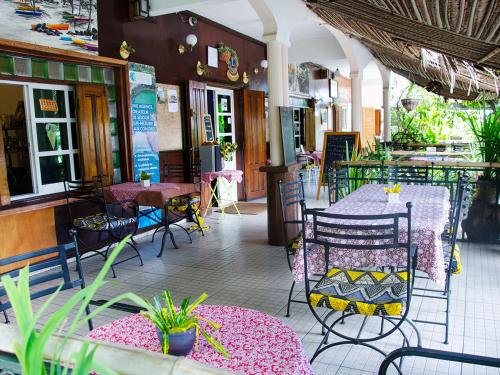 - un restaurant avec des tables, des chaises, une table et des chaises dans l'établissement Hotel Jardin de la Paix, à Moroni