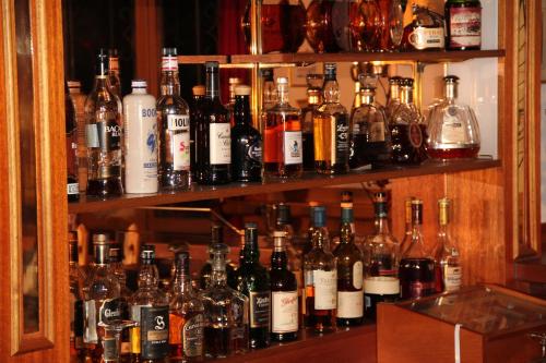a shelf filled with lots of bottles of alcohol at Hotel Gspan in Arosa