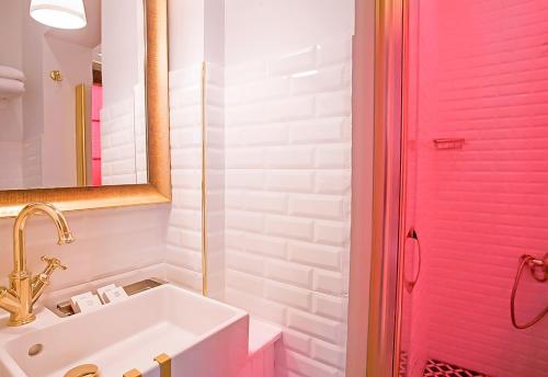 a bathroom with a sink and a pink shower door at Araf Hotel in Konya