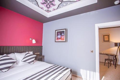 a bedroom with a bed and a pink wall at Araf Hotel in Konya