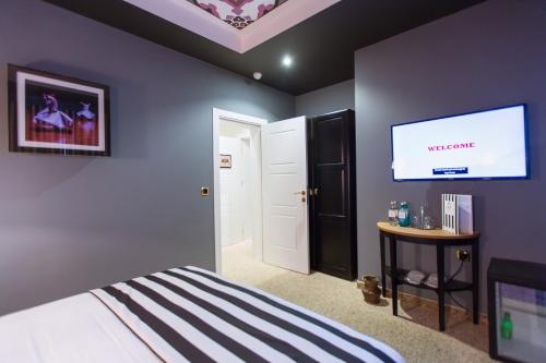 a bedroom with a bed and a flat screen tv at Araf Hotel in Konya