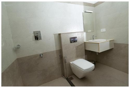 a bathroom with a toilet and a sink at Holiday Vagamon in Vagamon