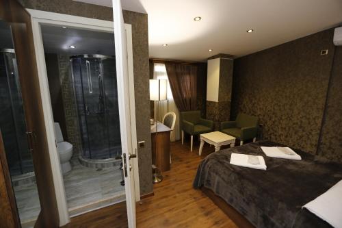 um quarto de hotel com uma cama e um chuveiro em Grand GMP em Tbilisi