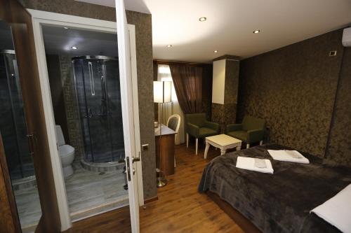 a hotel room with a bed and a shower at Grand GMP in Tbilisi City