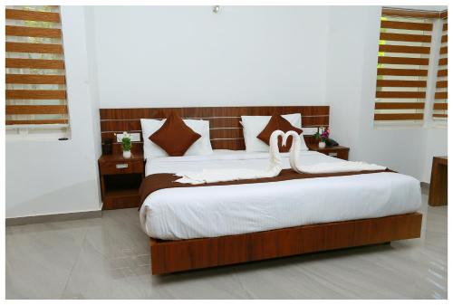 a bedroom with a bed with two white shoes on it at Holiday Vagamon in Vagamon