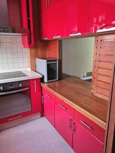 a red kitchen with red cabinets and a microwave at Wonderful Sea Views by Vapagó Tenerife in Costa Del Silencio