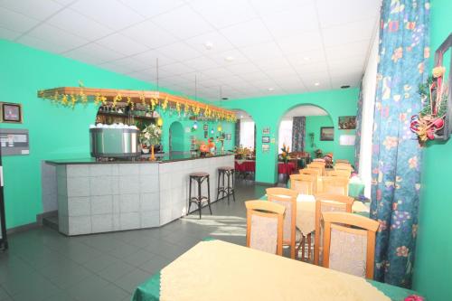 ein Restaurant mit grünen Wänden und Tischen und eine Bar in der Unterkunft Willa Ewa in Jantar