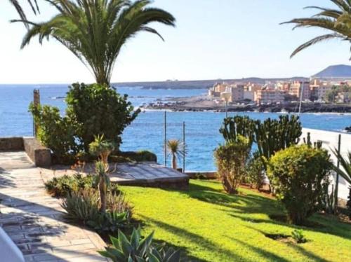 a garden with palm trees and a body of water at Wonderful Sea Views by Vapagó Tenerife in Costa Del Silencio
