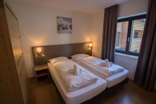 a bedroom with two beds and a window at Appart Gastauer in Sankt Gallenkirch