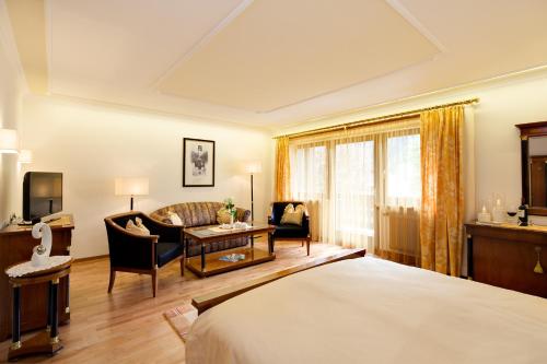 a hotel room with a bed and a living room at Romantik Hotel & Restaurant Stafler in Vipiteno