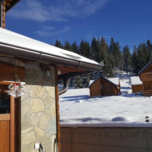 a snow covered roof of a cabin with a snow covered yard at Resort Skrivena in Berane