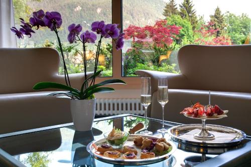 a table with two plates of food on a glass table at Grand Hotel Presolana in Castione della Presolana