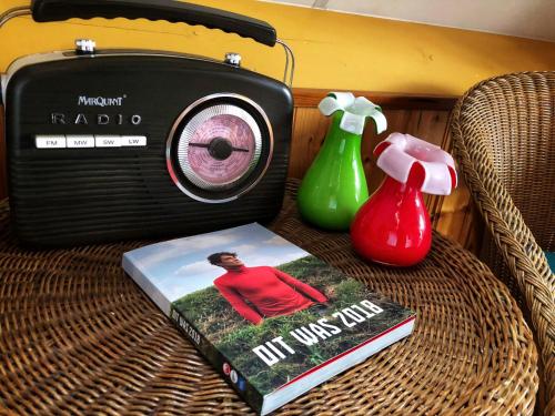 a book and a radio sitting on a table at B&B Zandhuizen in Zandhuizen