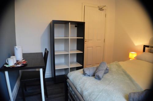 a bedroom with a desk and a bed and a table at Old Swan Guest House in Liverpool