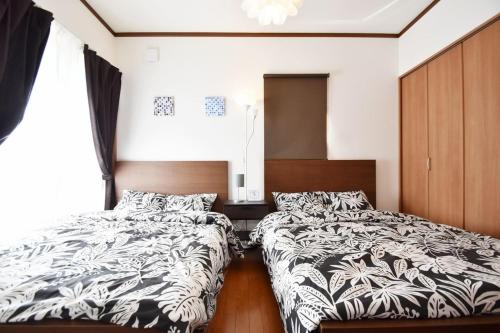 two beds sitting next to each other in a bedroom at Endless Summer in Shirako