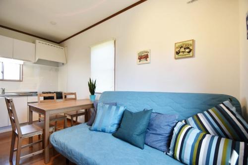 a living room with a blue couch and a table at Endless Summer in Shirako