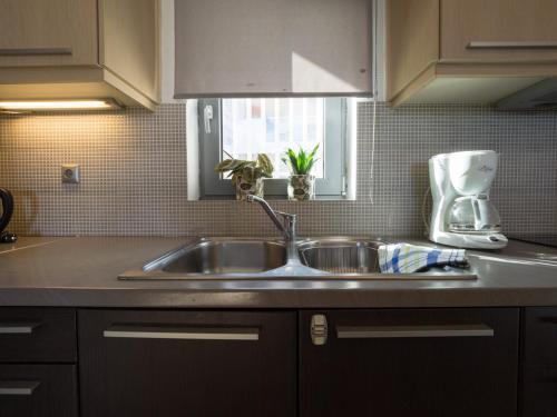 uma cozinha com um lavatório de aço inoxidável e uma janela em Almyra Hotel em Karfas