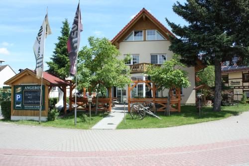 un edificio con bandiere di fronte di Pension Spreewaldstube a Vetschau