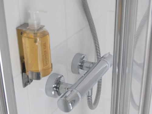 a soap dispenser in a shower door with at The Old Post House B&B in St Just