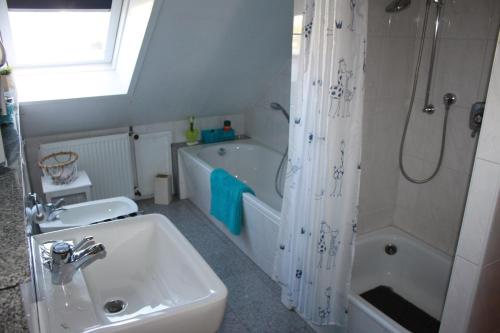 a bathroom with a sink and a tub and a shower at Ferienwohnung,Über Tage in Bochum