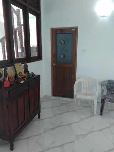 a room with a chair and a cabinet and a door at VILLA ARIANNA in Wattala