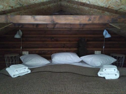 a bedroom with a bed with pillows and towels at Шаленарозі in Migovo