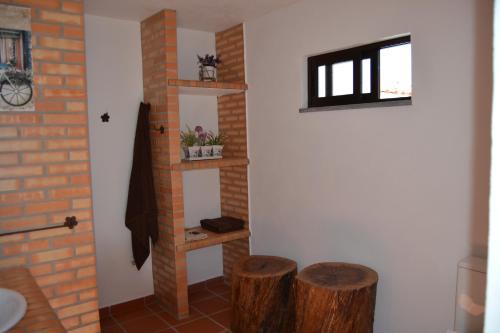 uma casa de banho com dois bancos de madeira ao lado de uma parede em Fazenda do Medronhal em Montemor-o-Novo