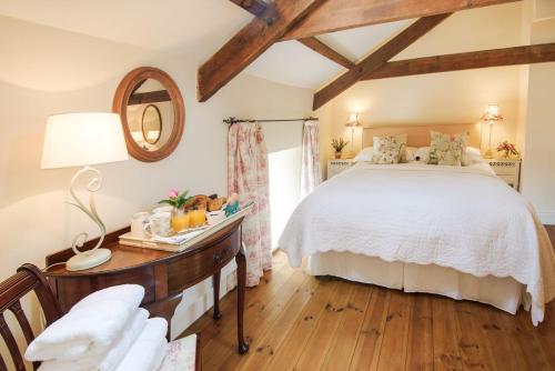 a bedroom with a bed and a table with a mirror at Middle Cottage Southlands Farm in Gunnerton