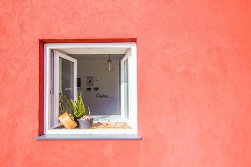 a window in a red wall with plants in it at Villa Mamma Mia Oprtalj in Oprtalj