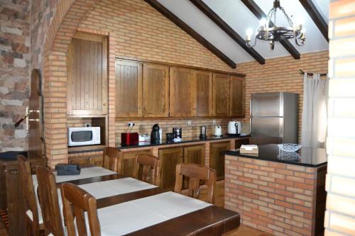 a kitchen with wooden cabinets and a brick wall at Fazenda do Medronhal in Montemor-o-Novo