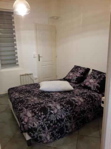um quarto com uma cama com um cobertor roxo em L'appart em Reims