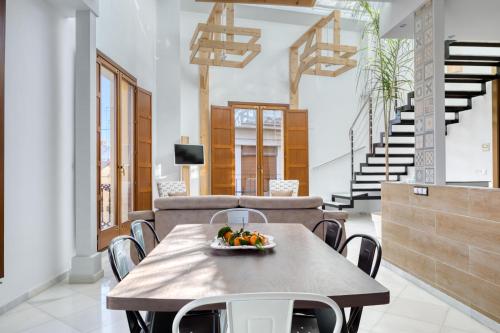 a dining room with a table with a bowl of fruit on it at Palau de Palomar - PalomarGroup in Valencia