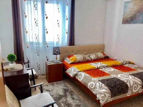 a bedroom with a bed and a table and a desk at Apartments Zuto in Ulcinj