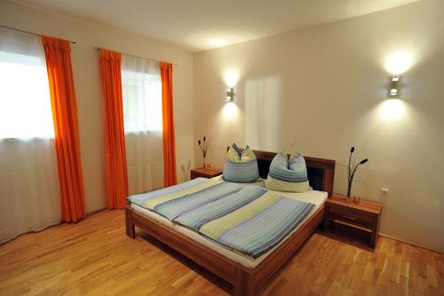 a bedroom with a bed with blue pillows on it at Appartements Altes Gericht in Hopfgarten im Brixental