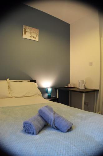 a blue towel laying on top of a bed at Old Swan Guest House in Liverpool
