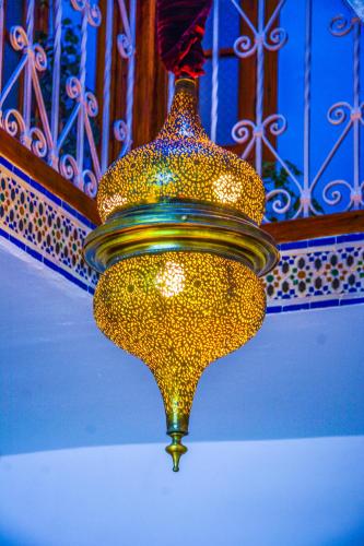 a gold chandelier is hanging from a ceiling at Riad Dari in Tetouan